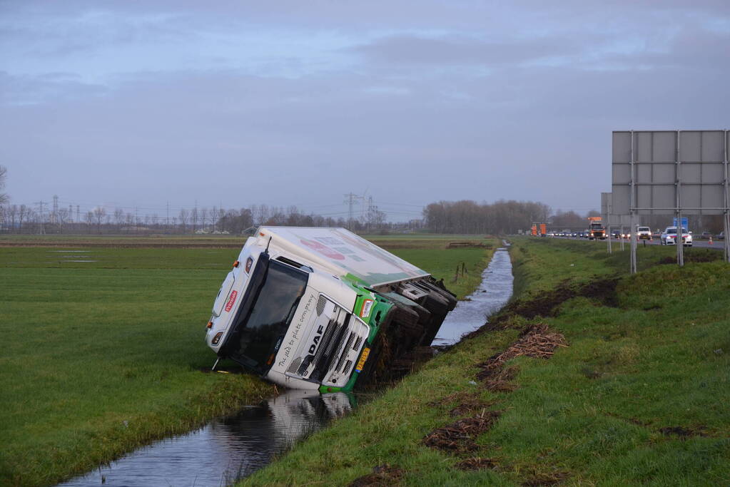 Vrachtwagen gekanteld in sloot naast snelweg