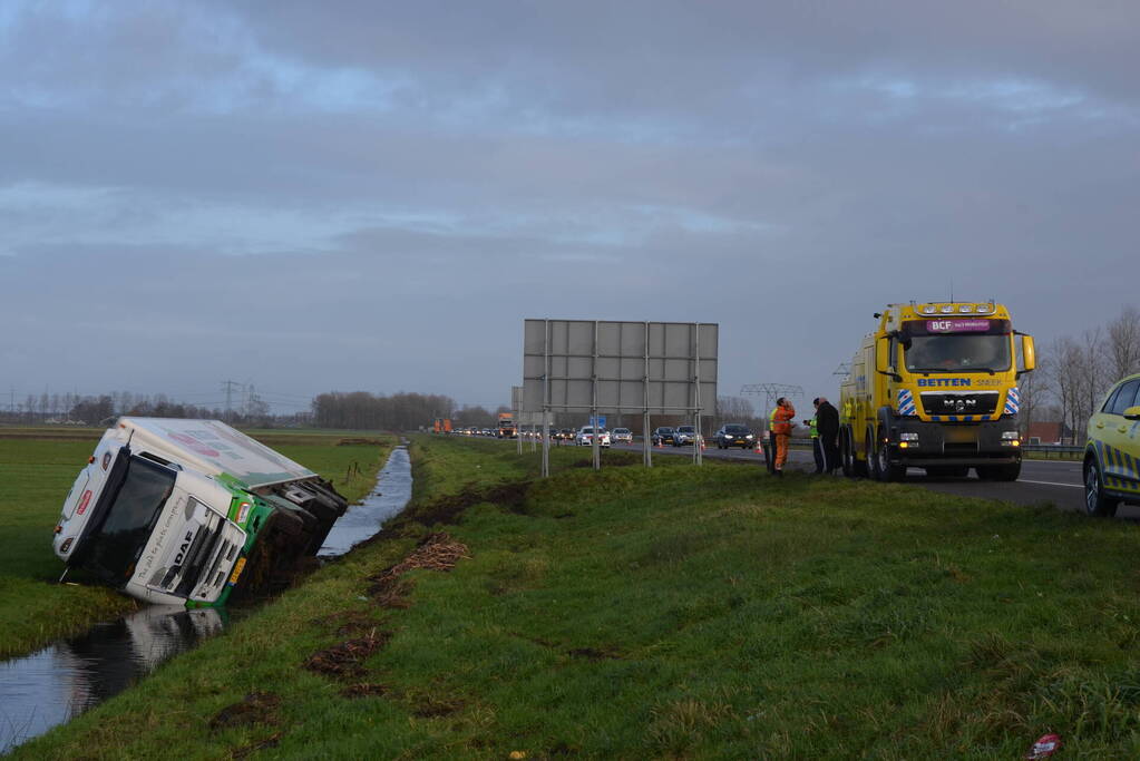 Vrachtwagen gekanteld in sloot naast snelweg