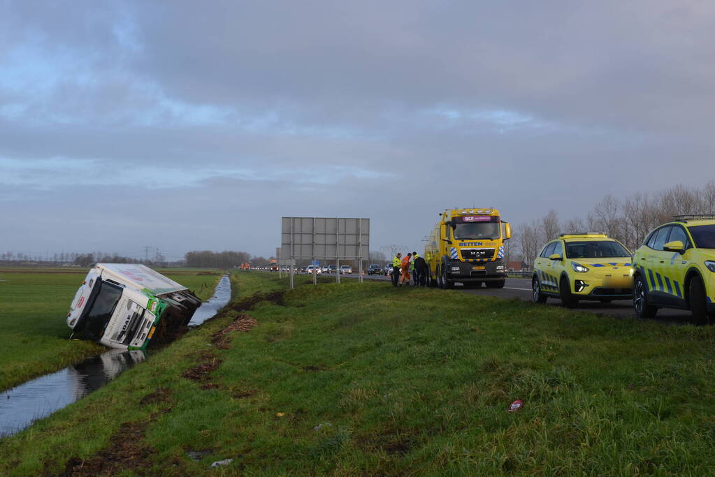 Vrachtwagen gekanteld in sloot naast snelweg