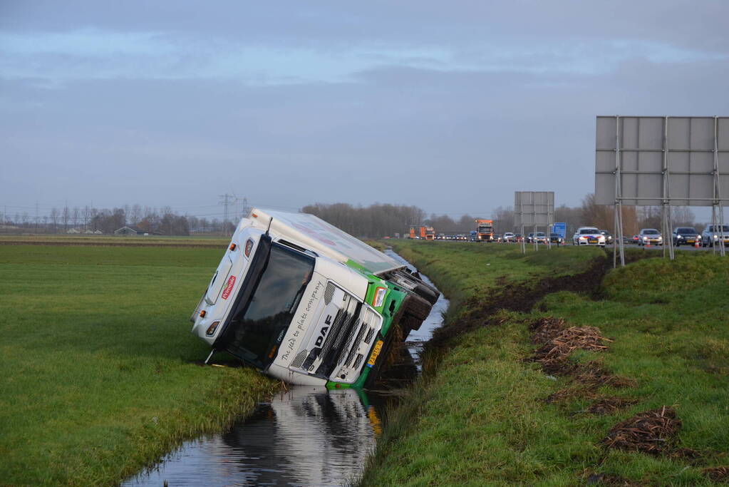 Vrachtwagen gekanteld in sloot naast snelweg