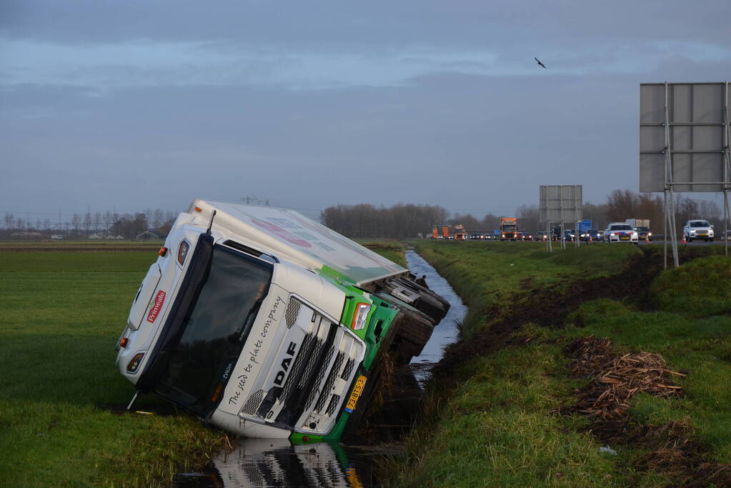 Vrachtwagen gekanteld in sloot naast snelweg