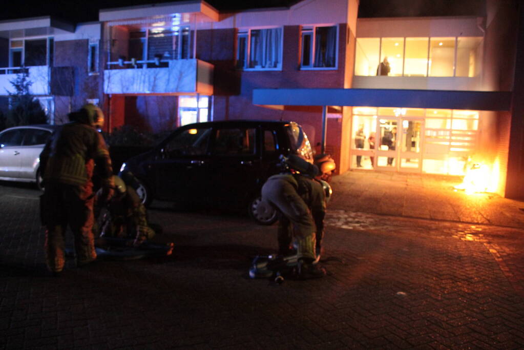 Brandweer blust brandende scooter tegen appartementencomplex