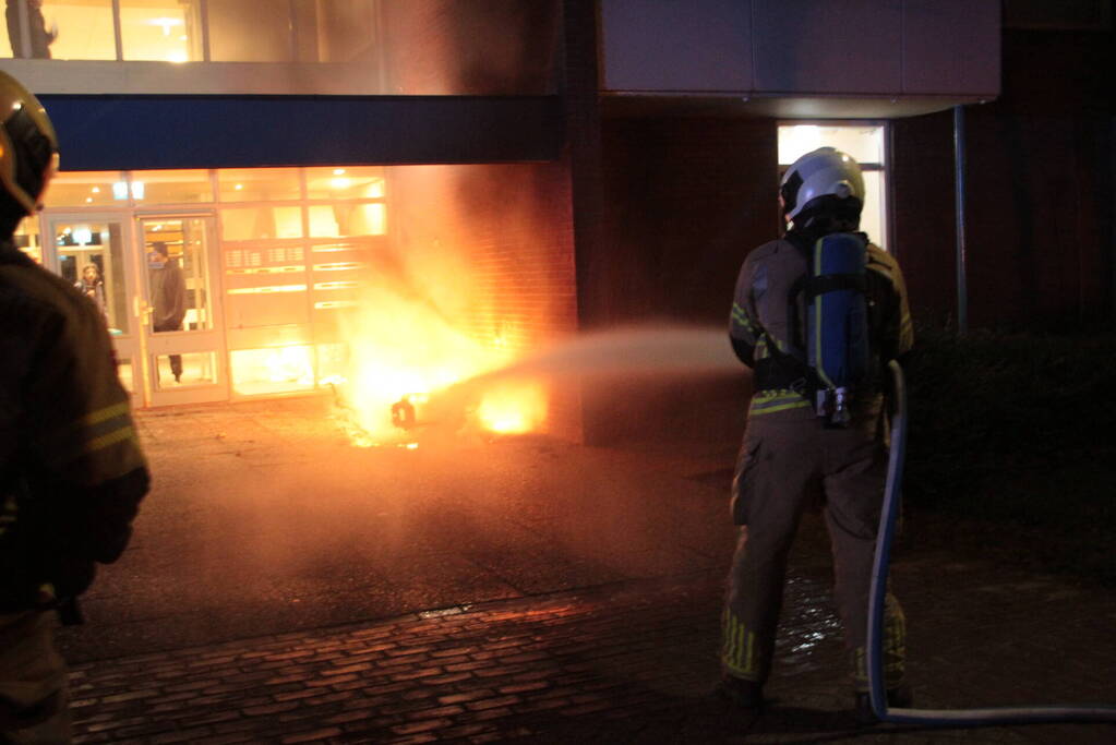 Brandweer blust brandende scooter tegen appartementencomplex