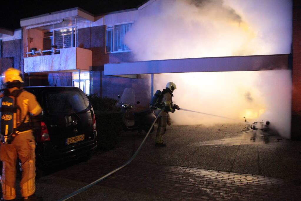 Brandweer blust brandende scooter tegen appartementencomplex