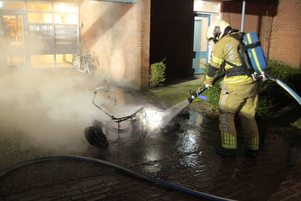 Brandweer blust brandende scooter tegen appartementencomplex