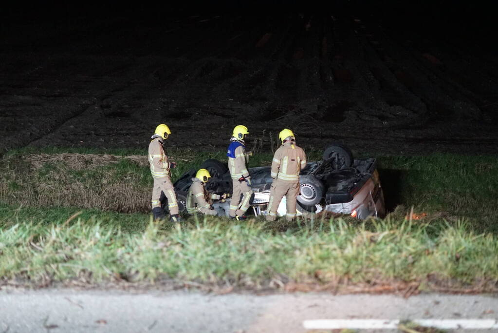 Auto raakt van weg, schampt boom en belandt ondersteboven in de sloot