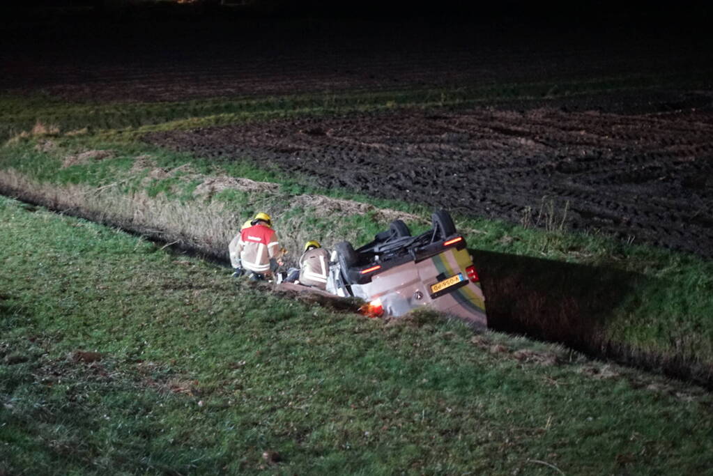 Auto raakt van weg, schampt boom en belandt ondersteboven in de sloot