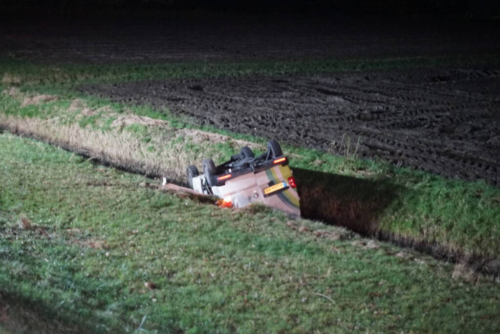 Auto raakt van weg, schampt boom en belandt ondersteboven in de sloot