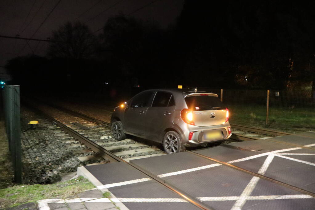 Persoon laat auto op spoor achter