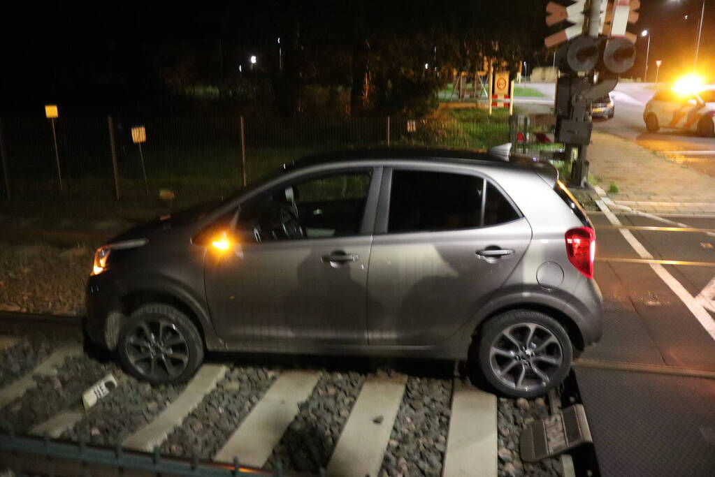 Persoon laat auto op spoor achter