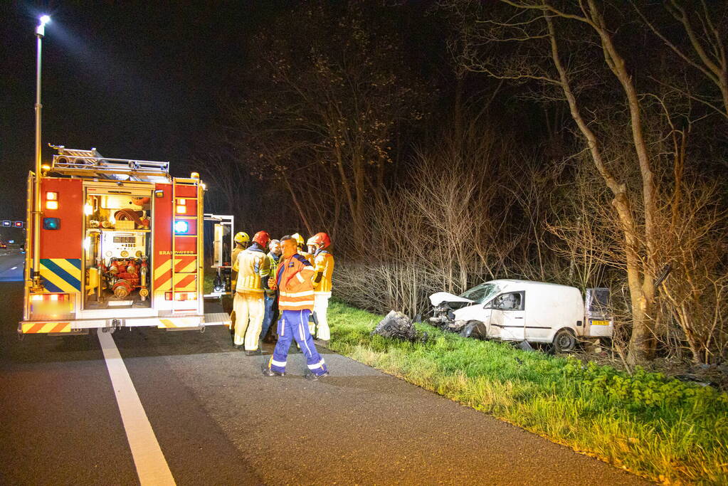 Bestelbus botst frontaal op boom naast snelweg