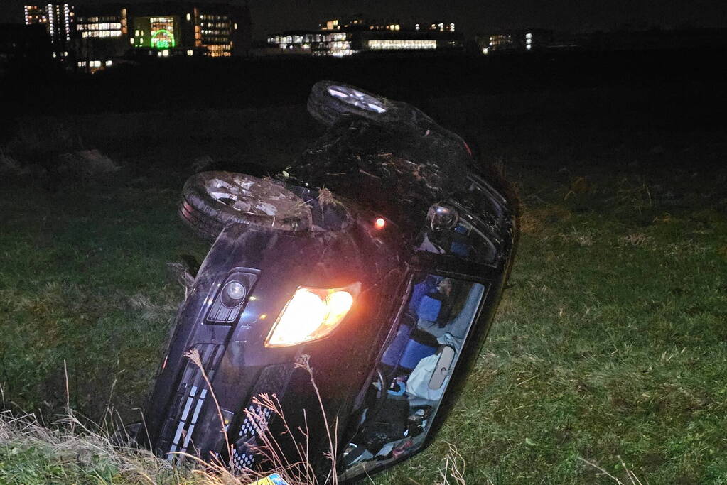 Auto belandt op zijkant in sloot na botsing met vrachtwagen