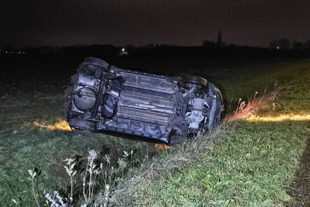 Auto belandt op zijkant in sloot na botsing met vrachtwagen