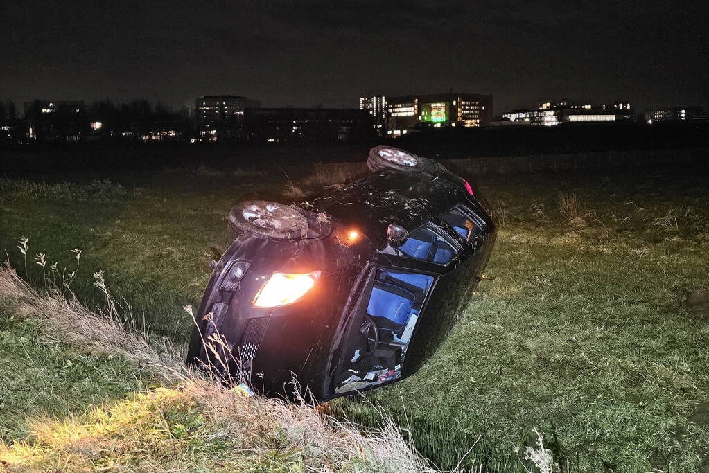 Auto belandt op zijkant in sloot na botsing met vrachtwagen