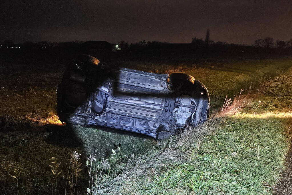 Auto belandt op zijkant in sloot na botsing met vrachtwagen