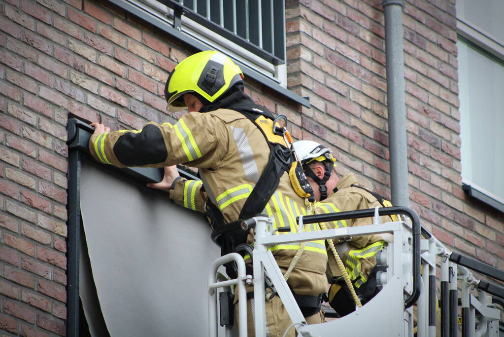 Brandweer zet loshangende zonnescherm vast