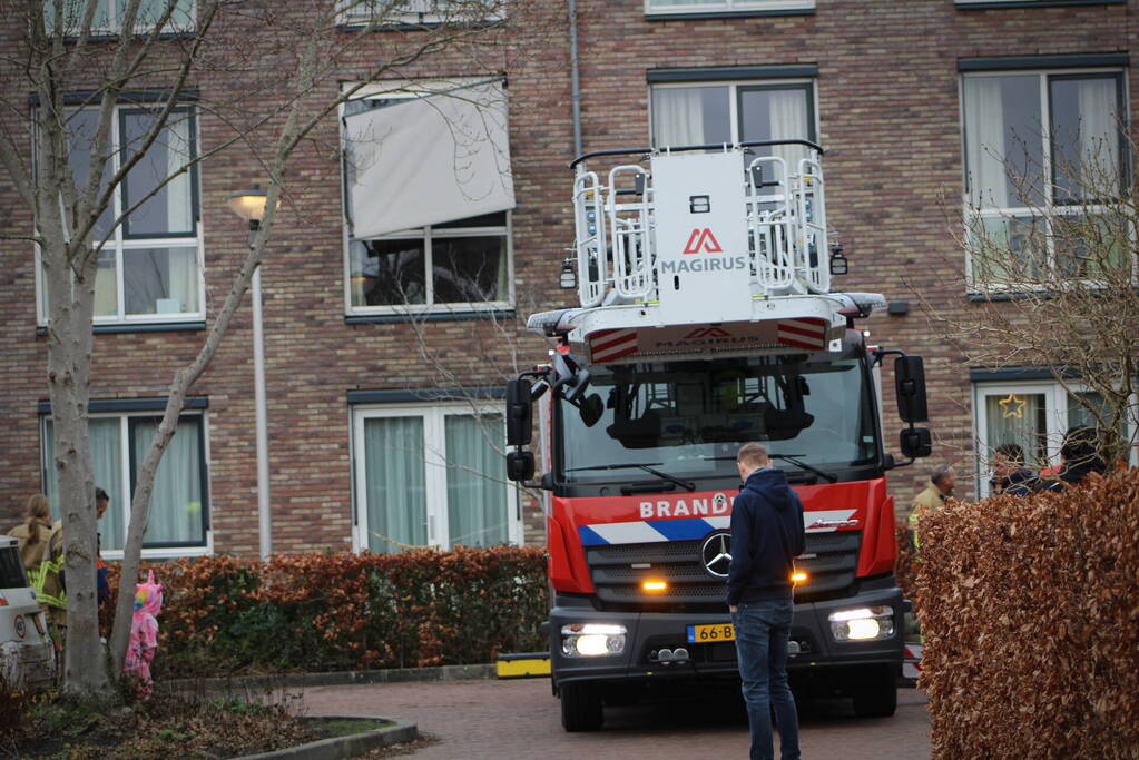 Brandweer zet loshangende zonnescherm vast