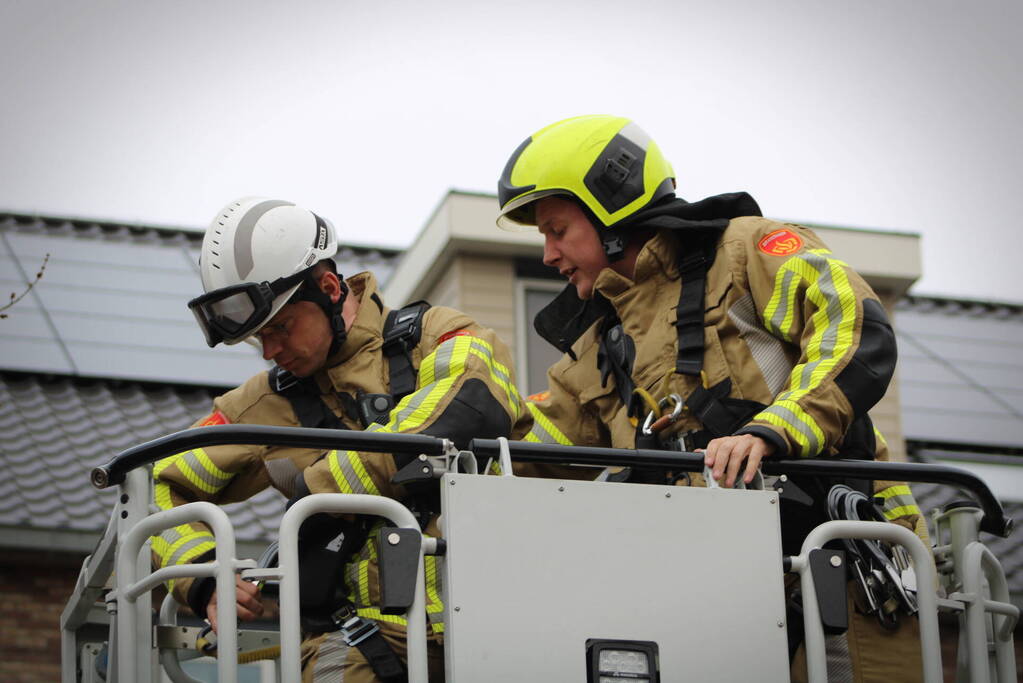 Brandweer zet loshangende zonnescherm vast