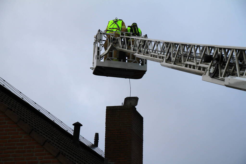 Brandweer blust brand in schoorsteen