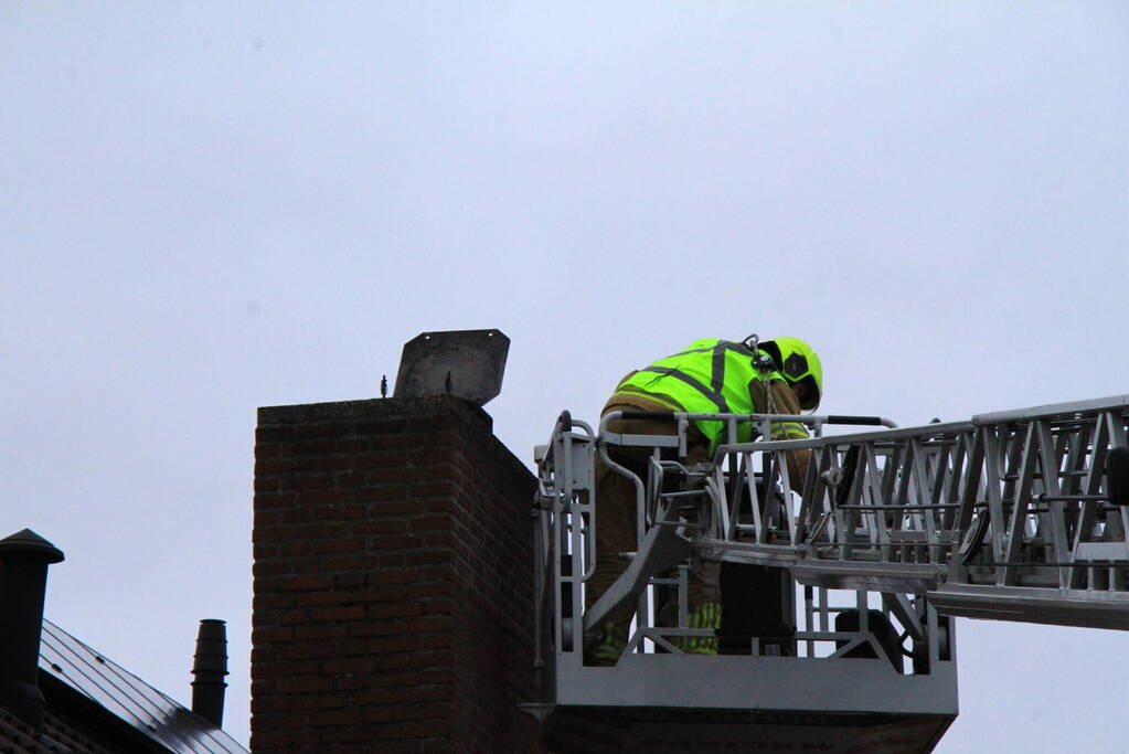 Brandweer blust brand in schoorsteen