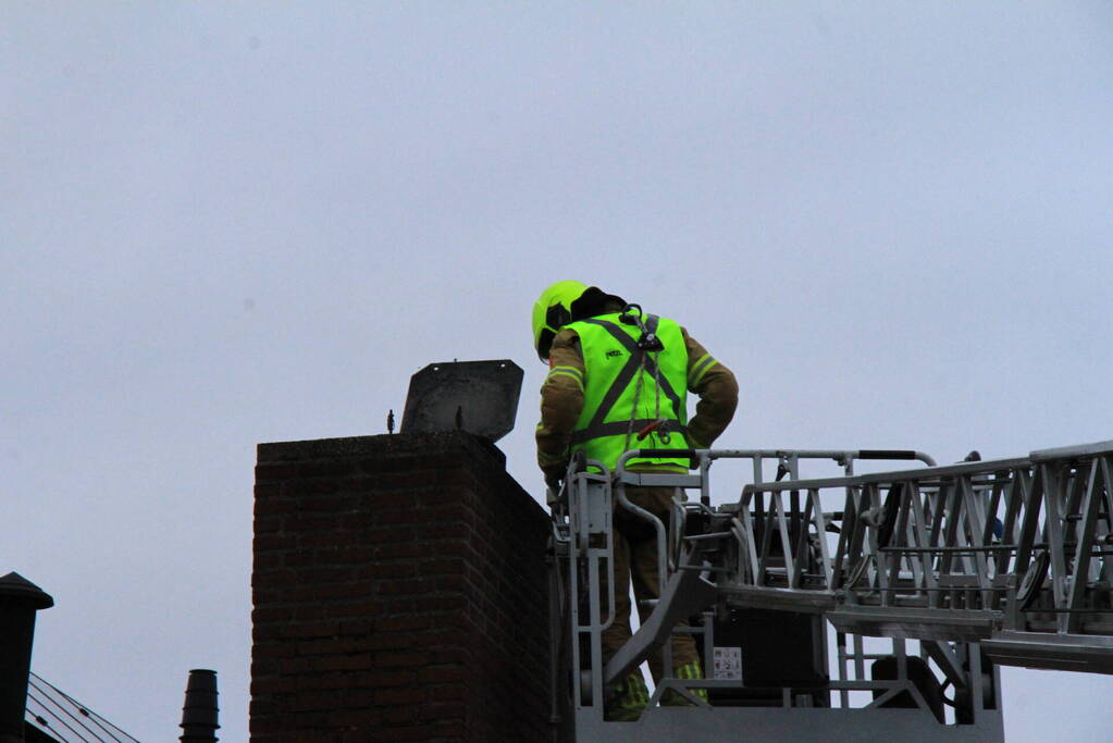 Brandweer blust brand in schoorsteen