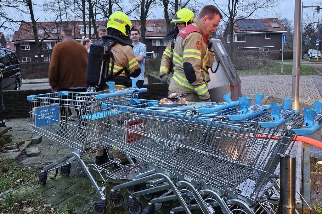 Brandweer blust ondergrondse container en wordt getrakteerd op oliebollen