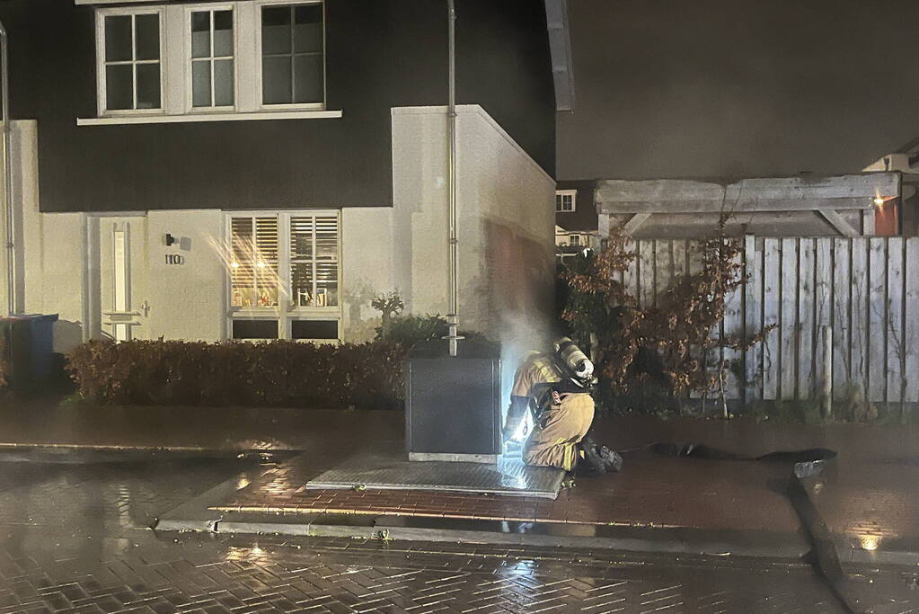 Brandweer blust brandende container