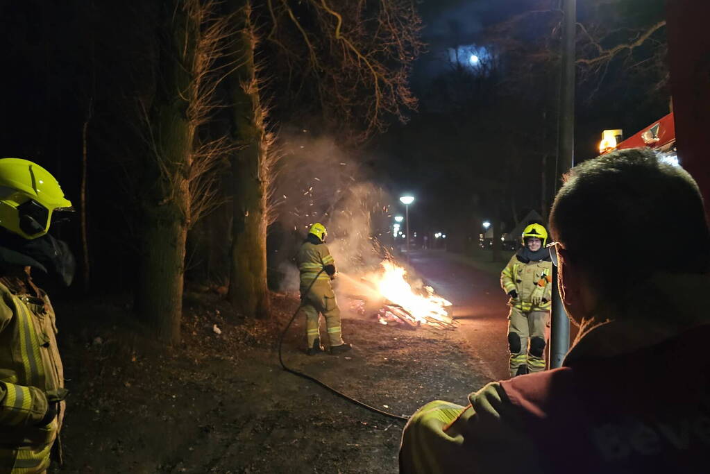 Brandweer blust stapel brandend hout