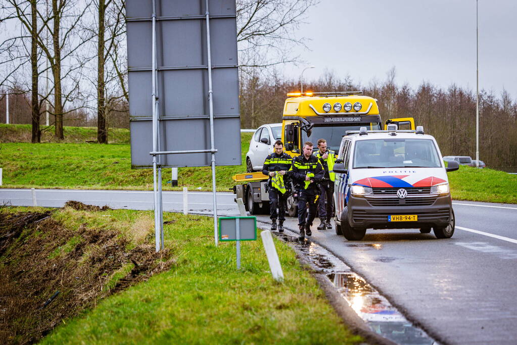 Auto raakt van de weg in bocht van afrit