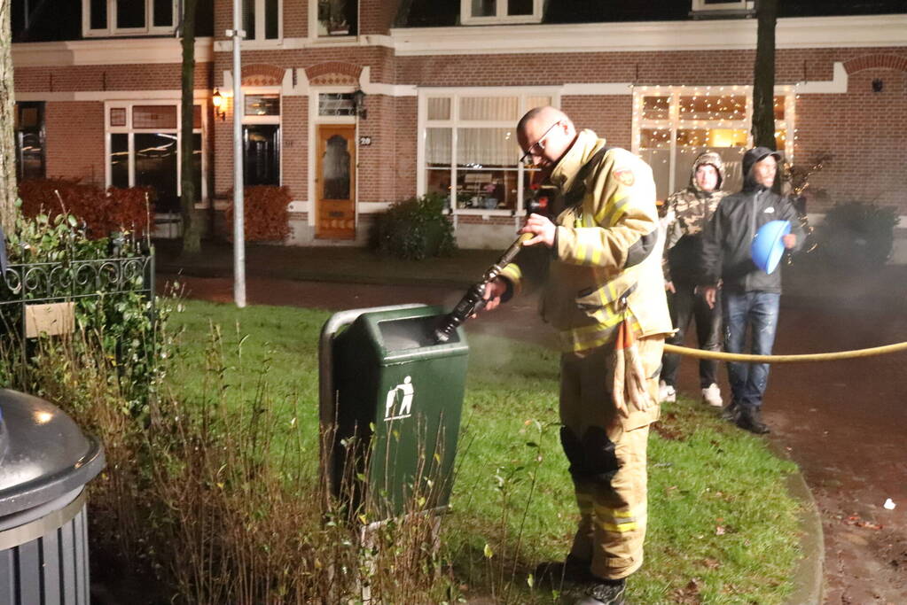 Brandweer blust brand in prullenbak