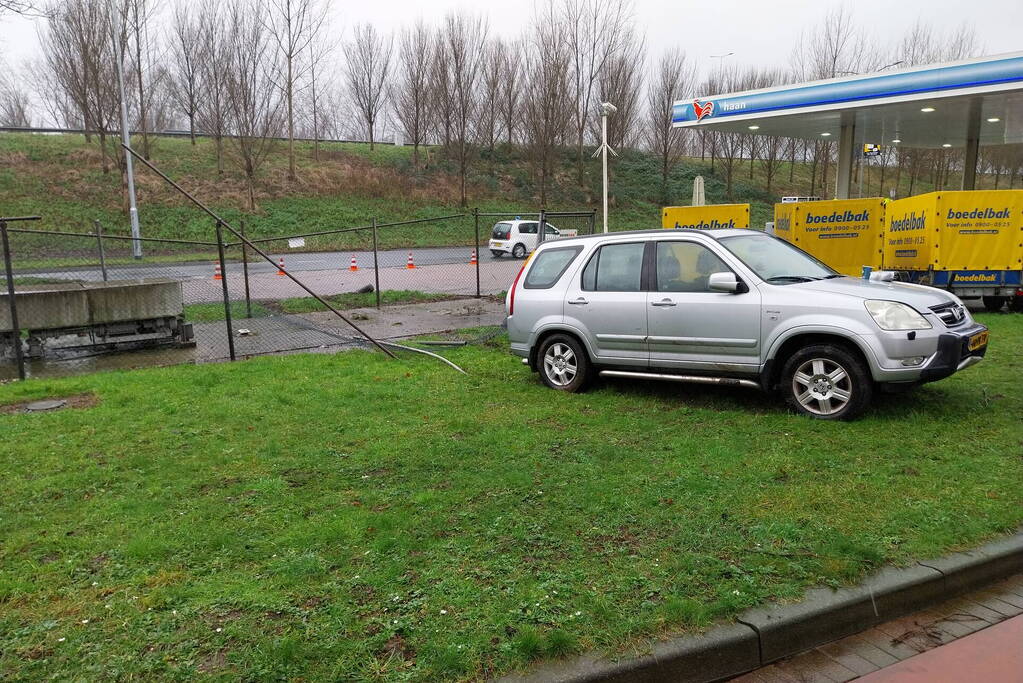 Automobilist rijdt door hekwerk van tankstation