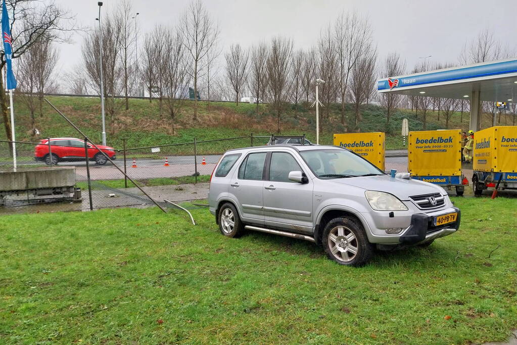 Automobilist rijdt door hekwerk van tankstation