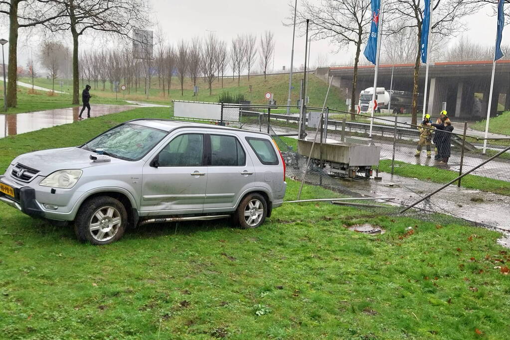 Automobilist rijdt door hekwerk van tankstation