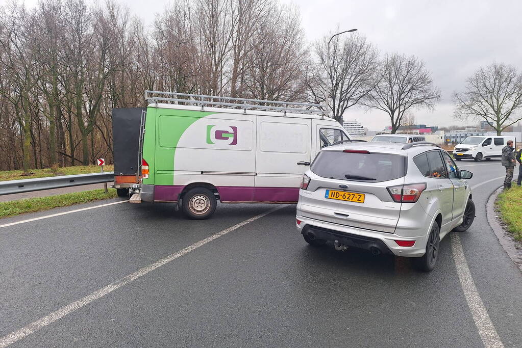 Bestelbus met aanhanger klapt op tegenligger