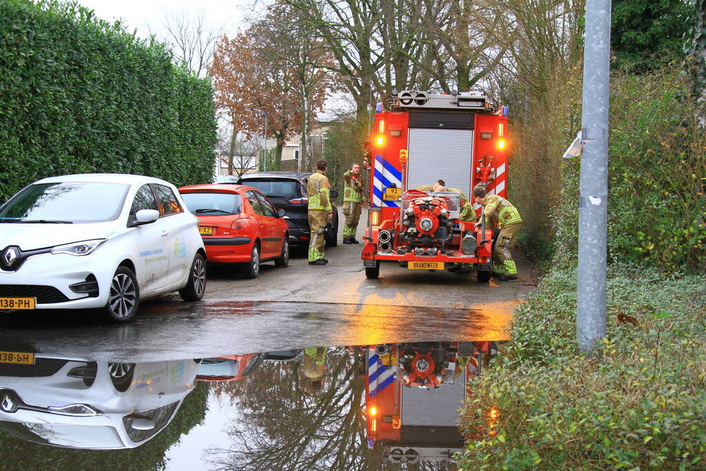 Straat onder water na overstroming riool