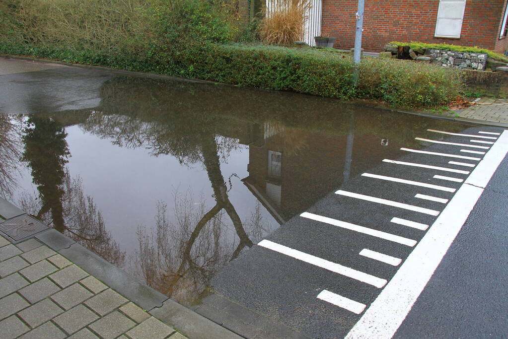 Straat onder water na overstroming riool