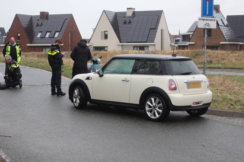 Scooterrijder schrikt van auto en gaat onderuit