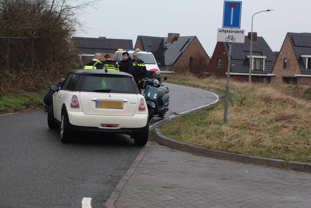 Scooterrijder schrikt van auto en gaat onderuit