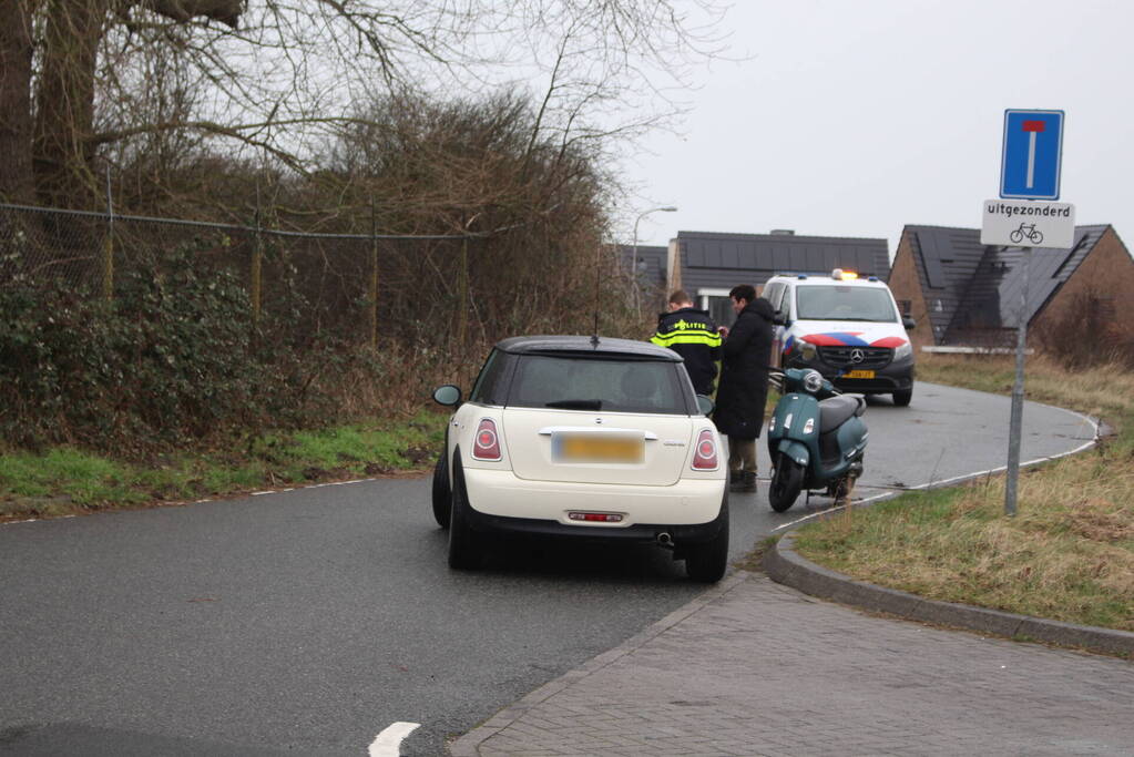 Scooterrijder schrikt van auto en gaat onderuit