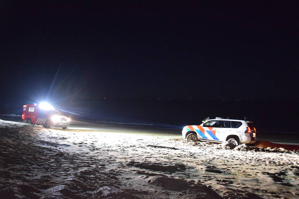 Politiejeep muurvast in los zand op strand