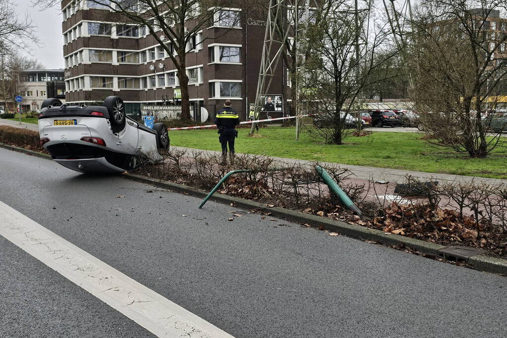 Automobilist ramt lantaarnpaal en slaat over de kop