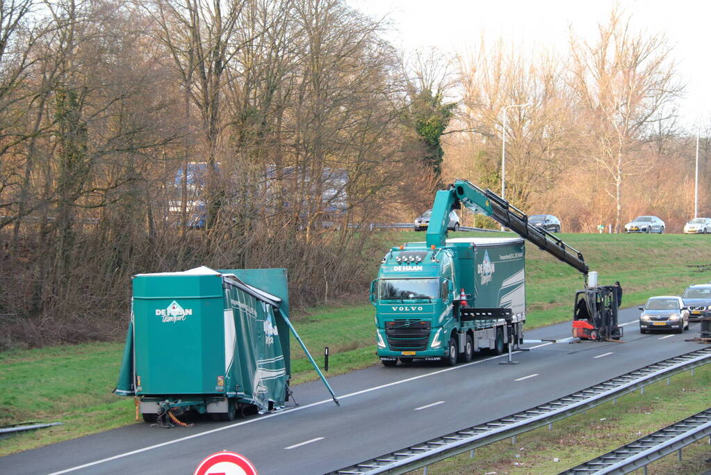 Vrachtwagen verliest twee heftrucks uit aanhanger