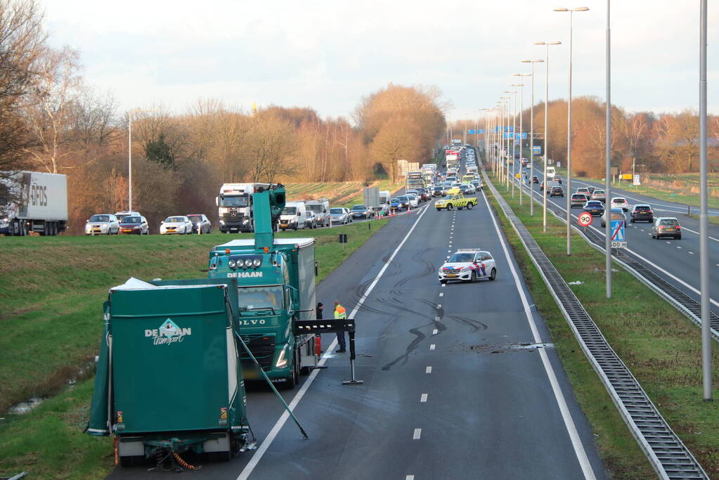 Vrachtwagen verliest twee heftrucks uit aanhanger