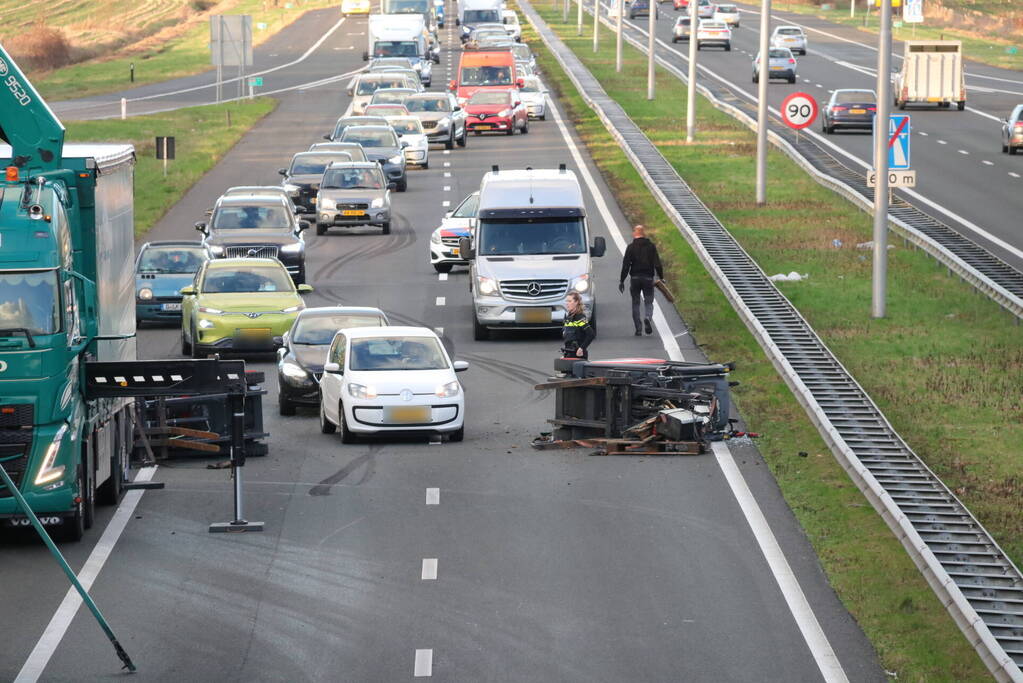 Vrachtwagen verliest twee heftrucks uit aanhanger