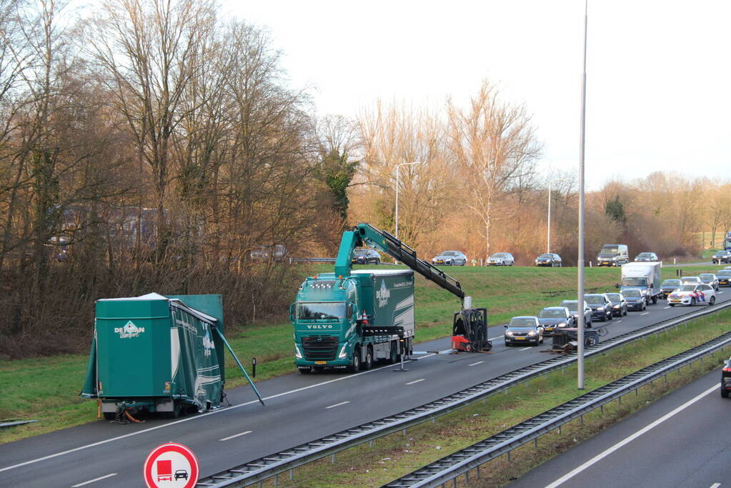 Vrachtwagen verliest twee heftrucks uit aanhanger