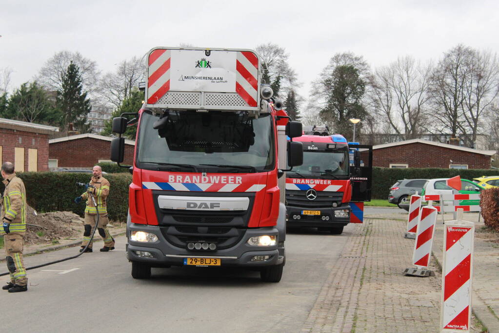 Brandweer blust brandend afval achter sloopwoningen