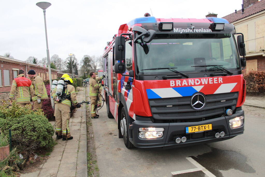 Brandweer blust brandend afval achter sloopwoningen