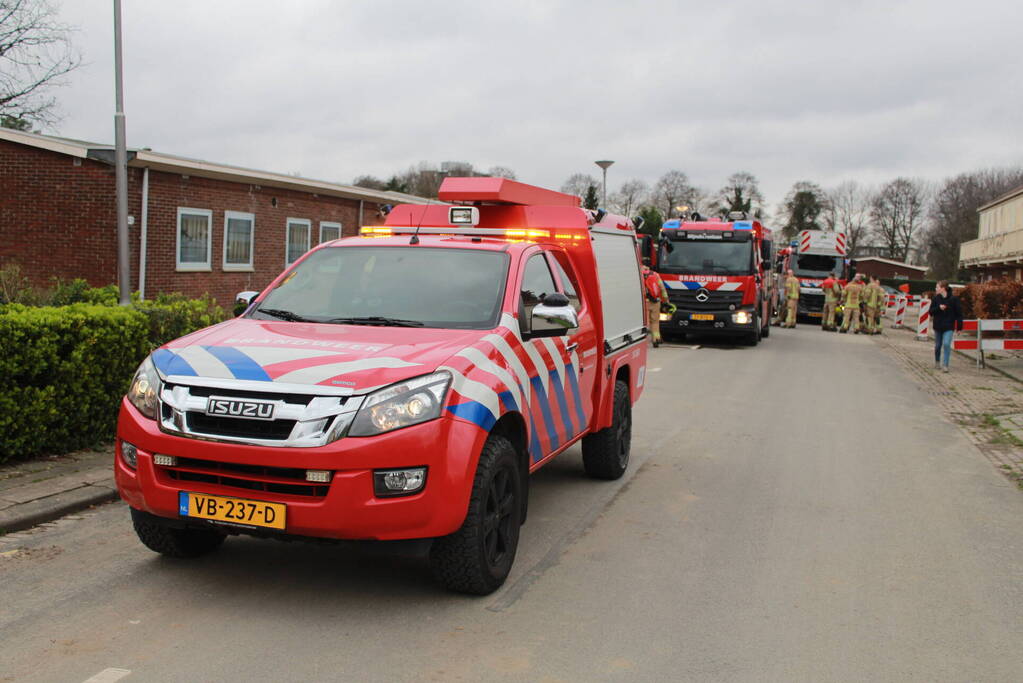 Brandweer blust brandend afval achter sloopwoningen