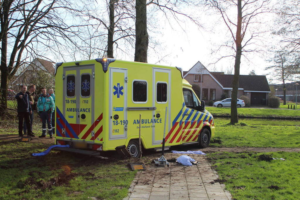 Vastgereden ambulance losgetrokken door graafmachine