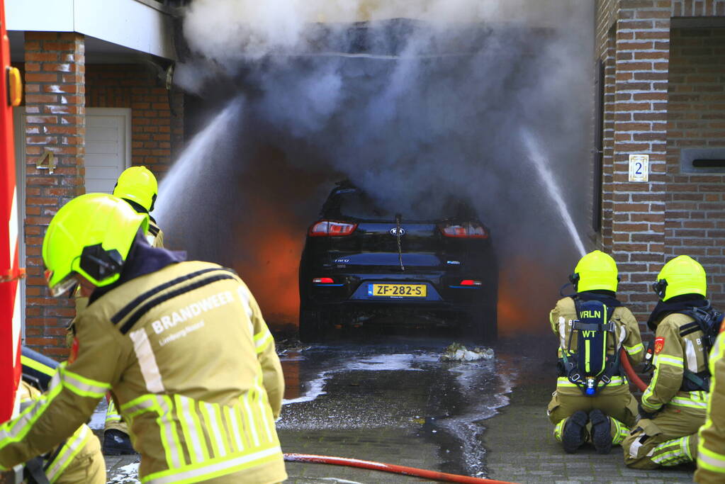 Personenauto vat vlam onder carport